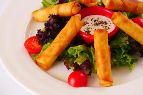 Sigara Borek. Deep-fried stuffed cheese sticks with sauce, tomato and lettuce Stock-Fotos