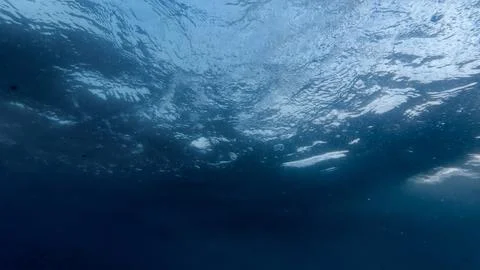 Sight from beneath the ocean floor as sunlight pierces through the water's su Stock Photos