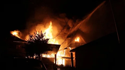 Sight of disarray at night showing multiple houses on fire in residential area Video stock 93616435