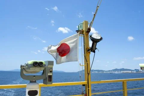 Sightseeing binoculars - telescope on back of ship with Japanese flag Stock Photos