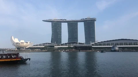 A sightseeing boat sailing pass towards the other side of Marina bay Stock Footage 124108832