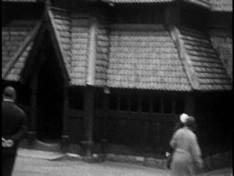 A sightseeing family views the Stave Church, a viking ship and a street market Stock Footage
