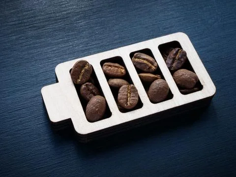 A sign of a battery charged with coffee beans as a symbol of cheerfulness and Stock Photos