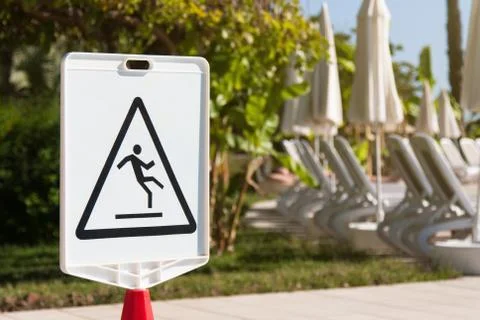Sign "Caution: Slippery" by the pool Stock Photos