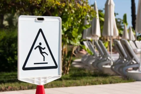 Sign "Caution: Slippery" by the pool Stock Photos