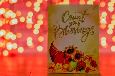 A Sign With a Cornucopia That Says Count Your Blessings With Orange Bokeh Beh Stock Photos