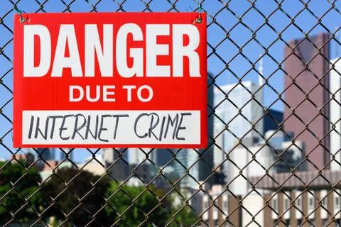 Sign danger due to internet crime hanging on the fence Stock Photos