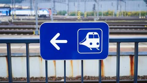 Sign directing passengers to train platform at busy railway station in urba.. Foto stock