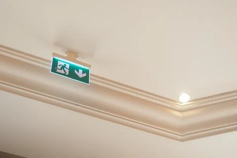 Sign for exit direction on ceiling in building Stock Photos