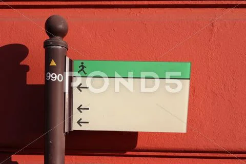 Sign in front of a red wall Stock Photos