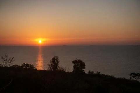 A sign in front of a sunset Stock Photos
