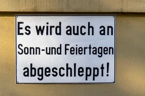A sign in German that says "Es wird uch an Sonn- und Feiertagen Abgeschleppt! Stock Photos