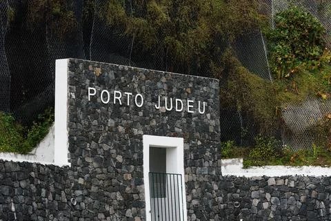 Sign of the harbour of Porto Judeu on volcanic wall Stock Photos
