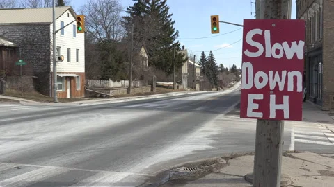 Sign on highway warning drivers to slow down and not speed in town Stockbeeldmateriaal 149896448