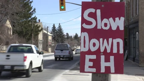 Sign on highway warning drivers to slow down and not speed in town Stockbeeldmateriaal 149897144