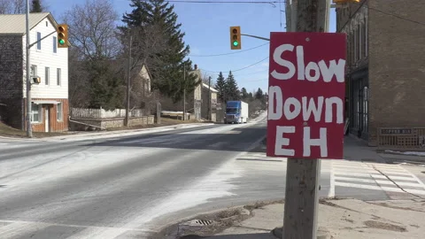 Sign on highway warning drivers to slow down and not speed in town Vídeos de archivo 149897576