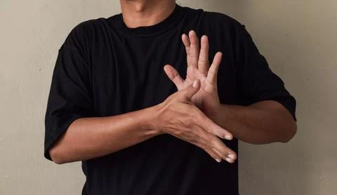 Sign Language man interpreter gesturing in sign language on gray background Stock Photos