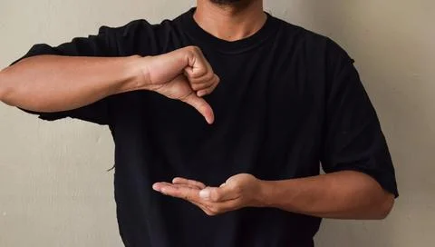 Sign Language man interpreter gesturing in sign language on gray background Stock Photos