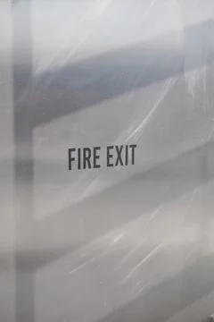 Sign marking a fire exit in a modern building's hallway Stock Photos