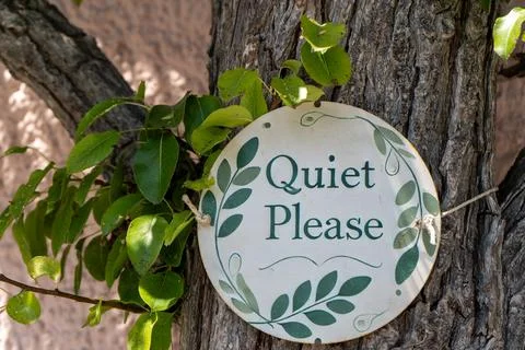 Sign with a Message Quiet Please Hanging on a Tree Trunk in a Garden Stock Photos