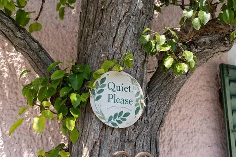 Sign with a Message Quiet Please Hanging on a Tree Trunk in a Garden Stock Photos