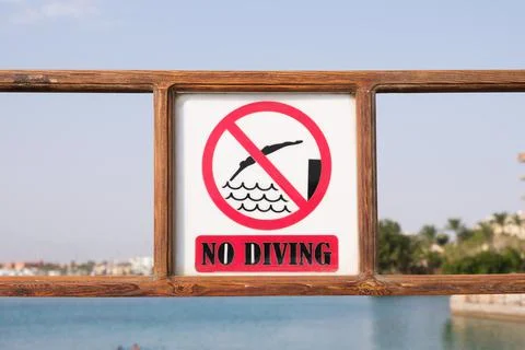 Sign no diving on the pier of the beach. A prohibitory sign warning of danger Stock Photos