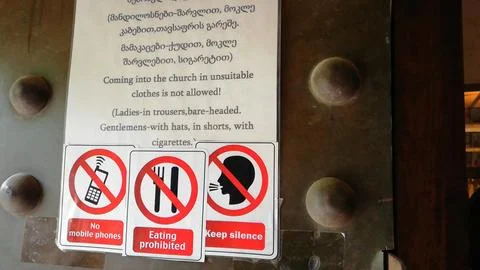 The sign outlines strict dress code rules in Georgian and English   스톡 사진