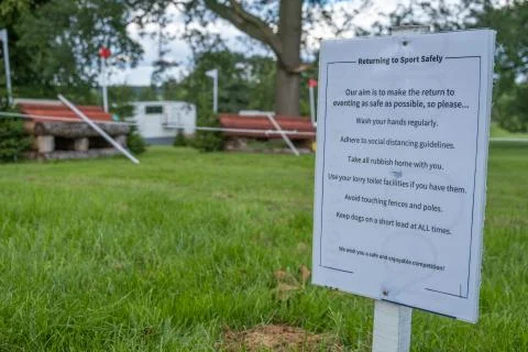 Sign outlining rules on a safe return to sport with COVID at an outdoor event Foto stock