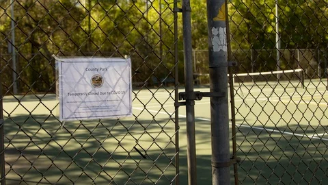 Sign at a park announcing closure due to Covid-19 virus. 4K Stock Footage 127254692