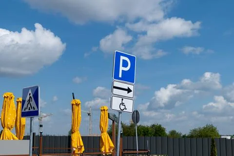 Sign posts show parking options and pedestrian crossings in a busy area wit.. Stock-Fotos