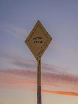 Sign: Power Cable, with evening clouds in the background, seen between Beal and Ilustração Stock