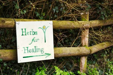 Sign reading 'Herbs for Healing' on a wooden fence in a garden. Stock Photos
