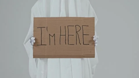 Sign reading ‘I am here’ in the hands of a ghost on a white background. Stock Footage 287915129