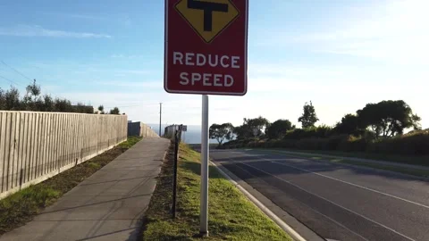 Sign of 'reduce speed' with a T-intersection warning on the roadside. Vídeos de archivo 274460367