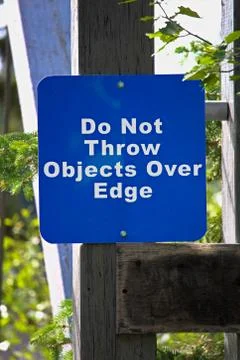 A sign requesting objects not be thrown over a platform edge Stock Photos