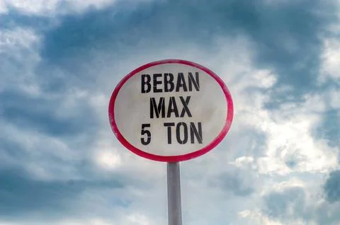 A sign that says maximum load or weight across the bridge with a cloudy sky.. Stock Photos
