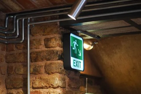 Sign showing exit direction in a building hallway Stock Photos