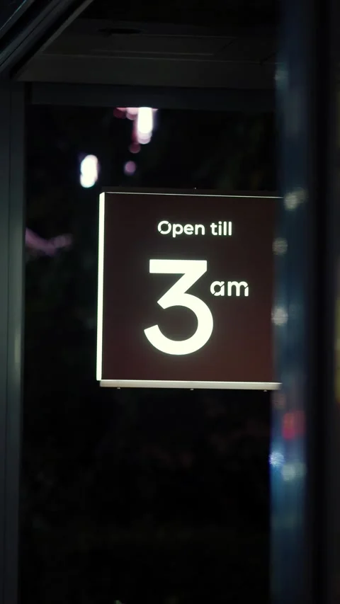 Sign shows business open till 3 AM at night outside establishment Stock Footage 345471753