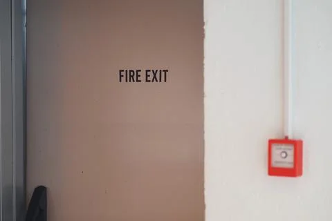 Sign shows fire exit in a building hallway Stock Photos