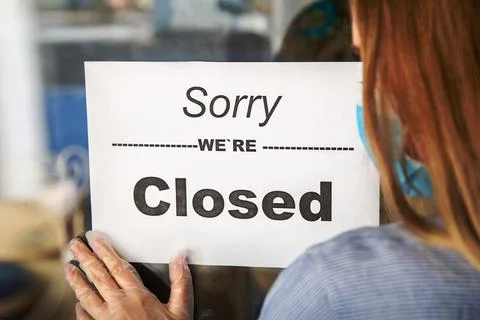 Sign Sorry we re closed on shop entrance door as new normal shutdown. Woman in Stock Photos