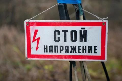 The sign stand voltage hanging on the wires Stock Photos