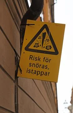 A sign with the text warning of sharp icicles Stock Photos