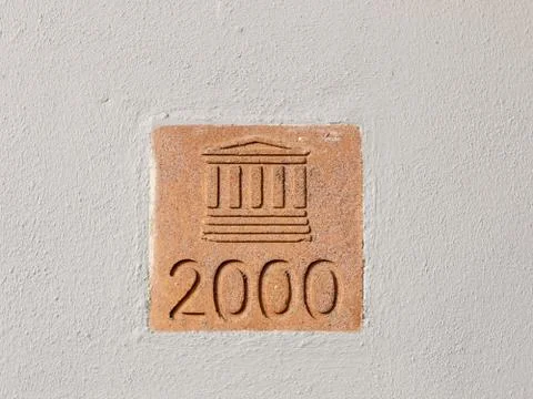 Sign on wall outside 2000 column building plaque Stock Photos