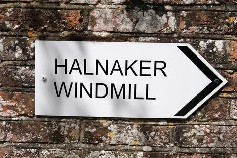 Sign on the wall pointing to.. Stock Photos