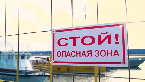 A sign warning of danger against the background of ships in the seaport Stock Footage 169809800