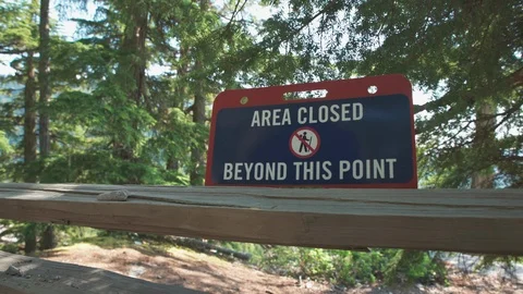 A sign warning hikers that a particular area of a trail in the woods is Stock Footage 109343103