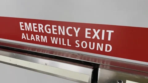 Sign with white text Emergency Exit Alarm will sound. Stock Footage 316802142