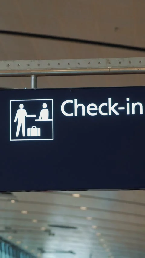 Signage indicating check-in process with two figures exchanging luggage at an Vidéo 329201796
