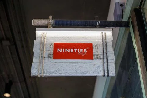 The signage of Nineties Design displayed on a rustic white wooden board Stock Photos