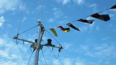 Signal code flags on a white mast flutter on a light breeze Stock Footage 114682312